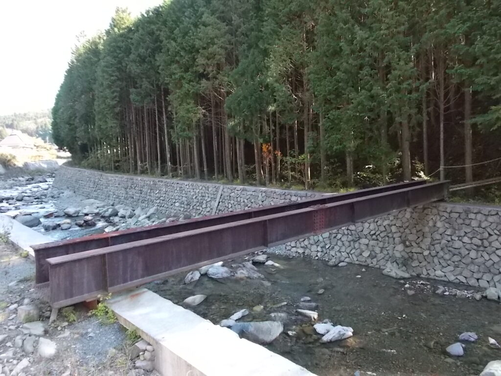 10:23 駐車場奥に進むと川を渡る鉄製の橋があります。これを渡ります。