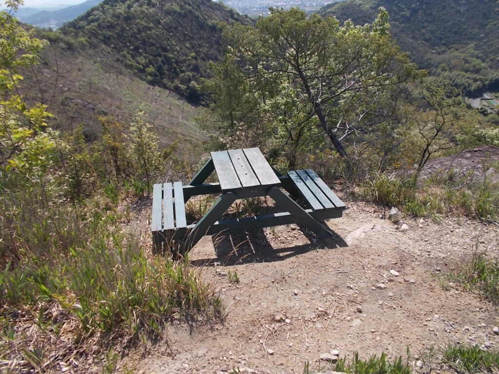 9：58　案内板の南側の斜面を下って、狭い登山道を降りていき、山頂手前からの長尾口への登山道に合流して尾根を降りていくと、ベンチがありました。