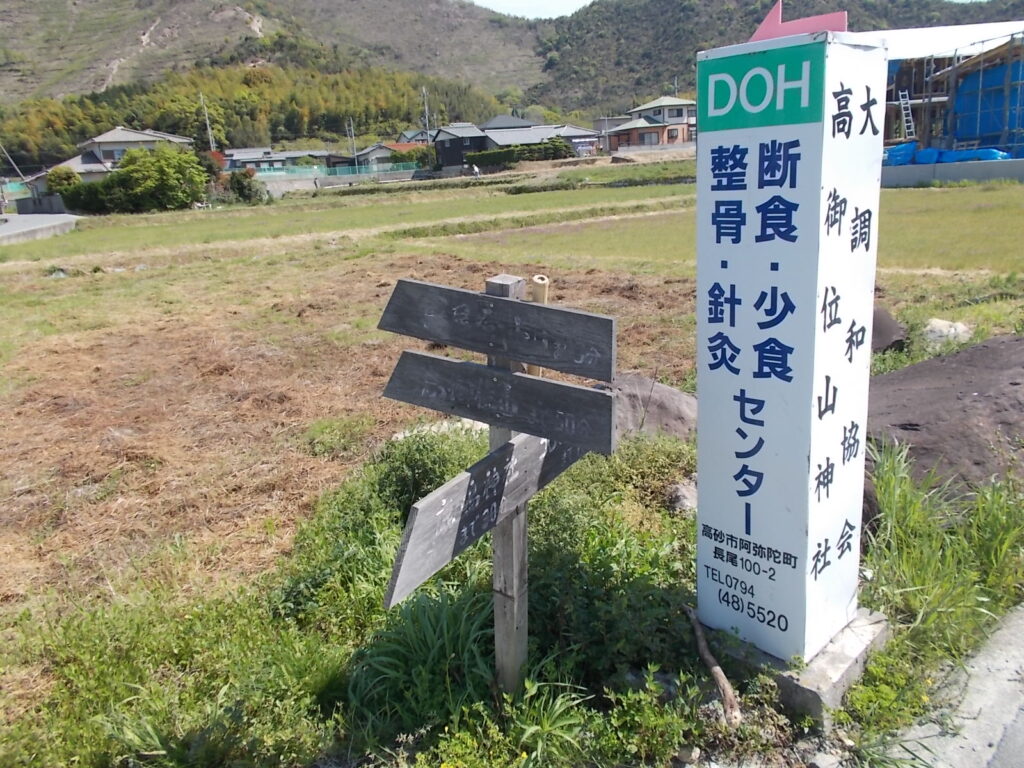 10：12　道路脇にある案内板。これもよく見えません。