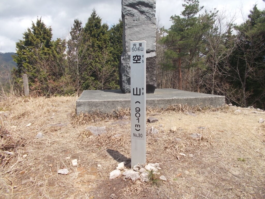 11:26 標柱をアップで。山頂は日当たり良好ですが、見晴らしは余り良くありません。