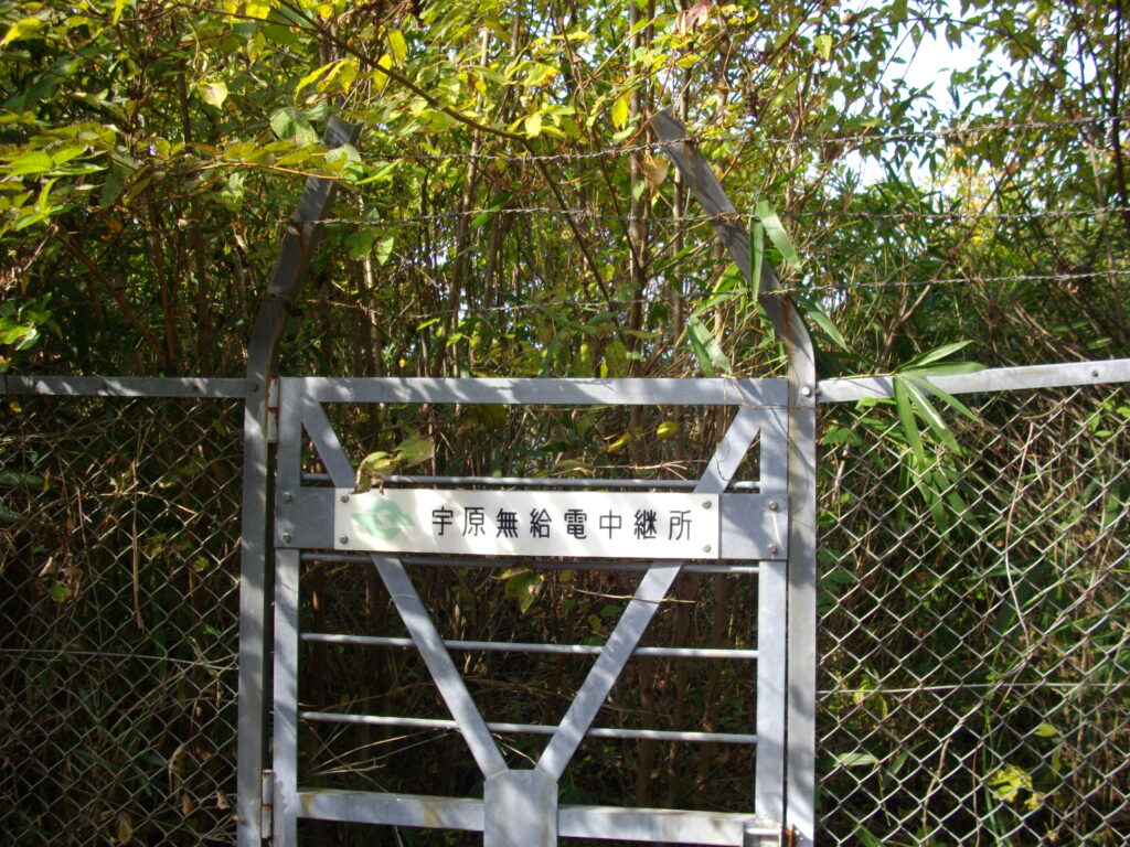 11：09　すぐ横にある宇原無給電中継所ですが、もう使われていないらしく、ごらんのように木がボウボウです。  日当たりが良さそうなので、ここで昼食にしました。