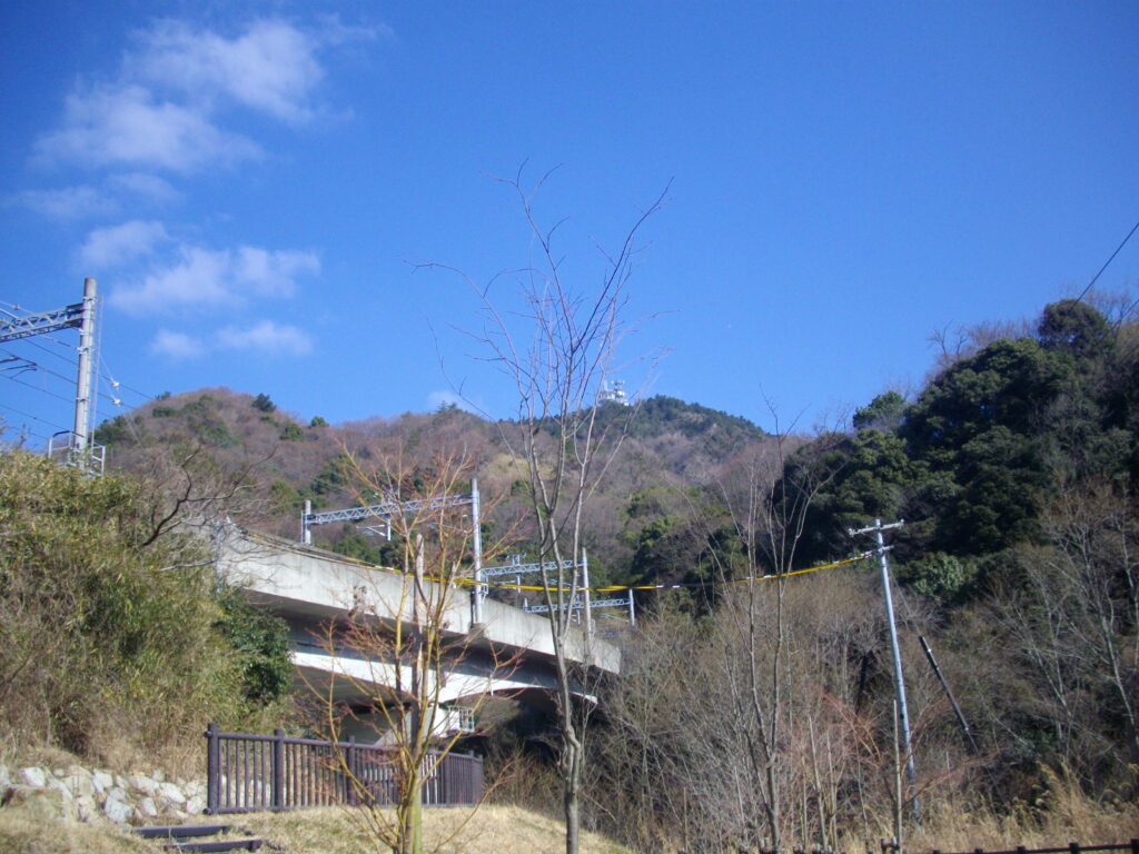 10：14　ちょっと開けたところを行くと、神鉄の高架があります。その向こうに菊水山が見えます。
